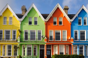 Rumah berjejer dengan warna kuning, hijau, oranye dan biru